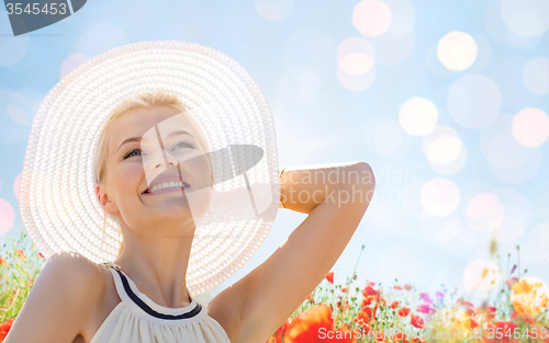 Image of smiling young woman in straw hat on poppy field