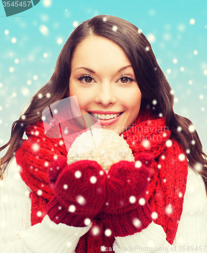 Image of woman in scarf and mittens with christmas ball