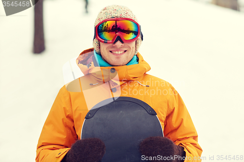 Image of happy young man in ski goggles outdoors