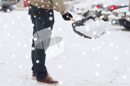 Image of closeup of man digging snow with shovel near car