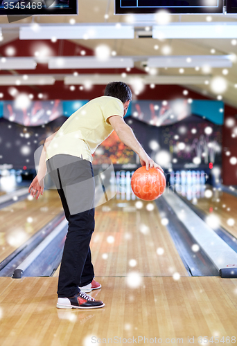 Image of young man throwing ball in bowling club