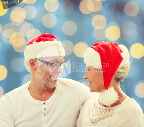 Image of happy senior couple in santa helper hats