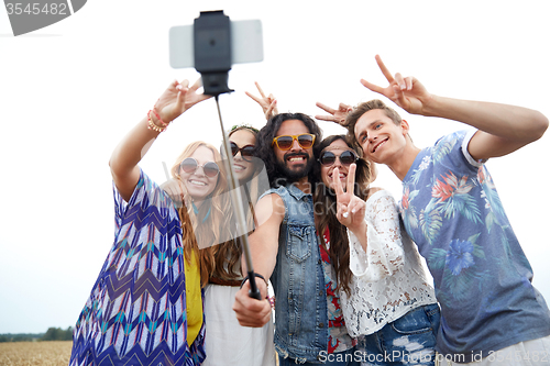 Image of hippie friends with smartphone on selfie stick