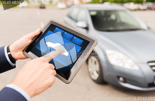 Image of close up of male hands with car icon on tablet pc