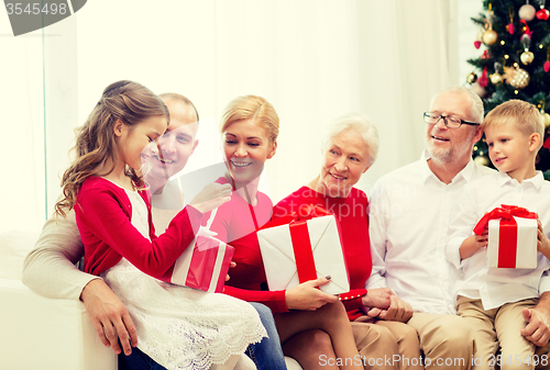 Image of smiling family with gifts at home