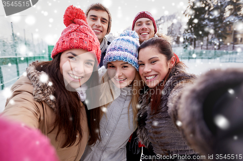Image of happy friends taking selfie with smartphone