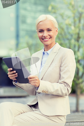 Image of smiling businesswoman with tablet pc outdoors