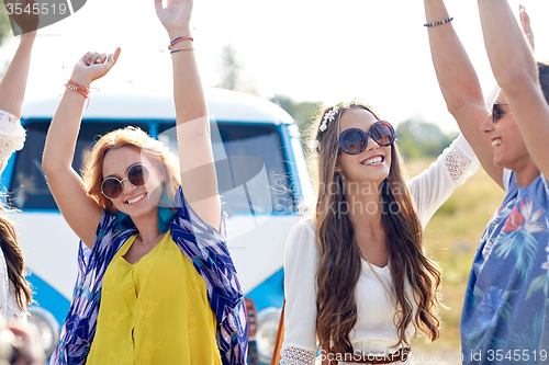 Image of happy young hippie friends dancing outdoors