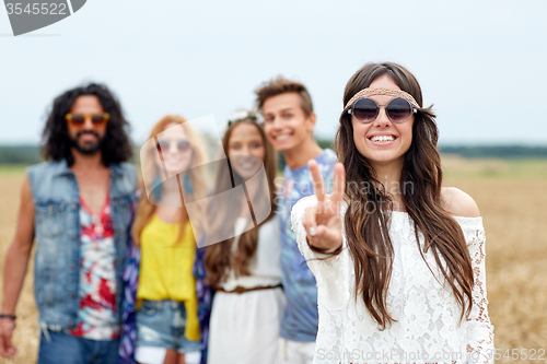 Image of happy young hippie friends showing peace outdoors