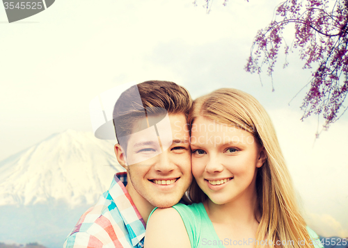 Image of smiling couple hugging over mountains background