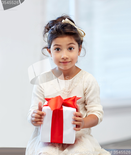 Image of happy little girl with gift box at home