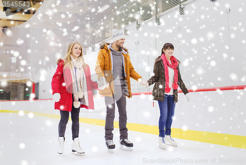 Image of happy friends on skating rink