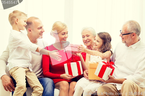 Image of smiling family with gifts at home