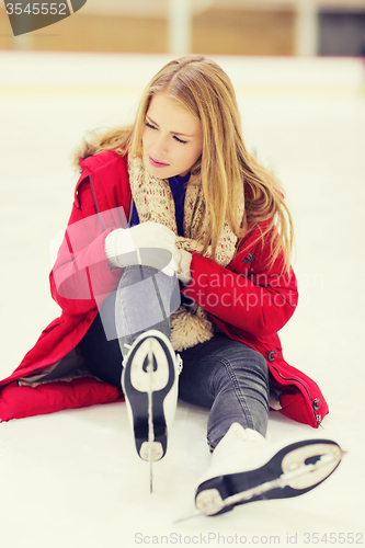 Image of young woman fell down on skating rink