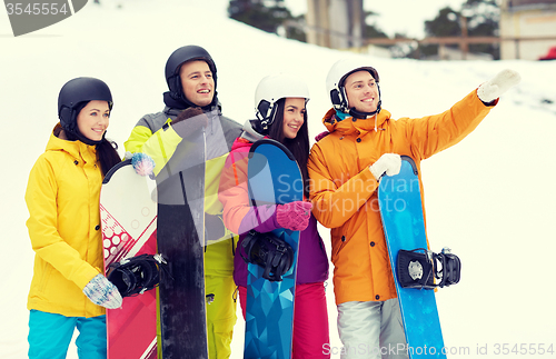 Image of happy friends in helmets with snowboards