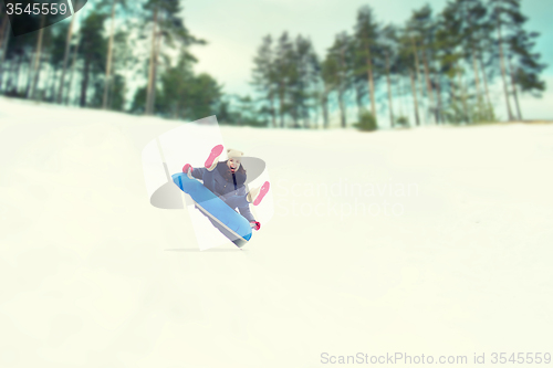 Image of happy teenage girl sliding down on snow tube