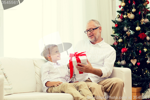 Image of smiling grandfather and grandson at home