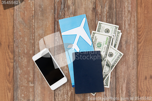 Image of air ticket, money, smartphone and passport