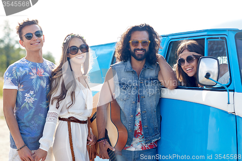 Image of happy hippie friends with guitar over minivan car