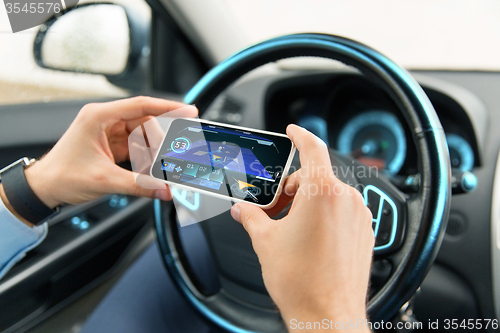 Image of hands with navigator on smartphone in car