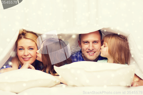 Image of happy family with two kids under blanket at home