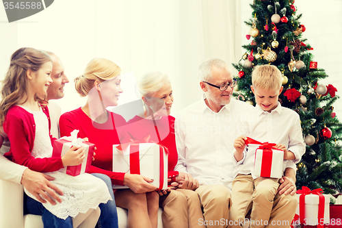 Image of smiling family with gifts at home