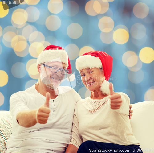 Image of happy senior couple in santa helper hats