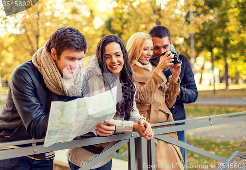 Image of group of friends with map and camera outdoors