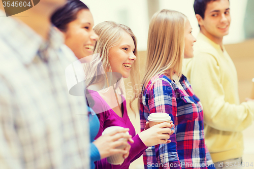 Image of group of smiling students with paper coffee cups