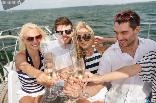 Image of smiling friends with glasses of champagne on yacht