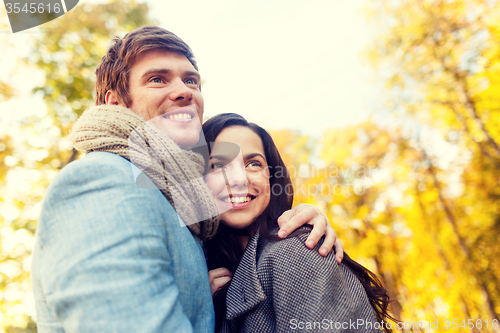 Image of smiling couple hugging in autumn park