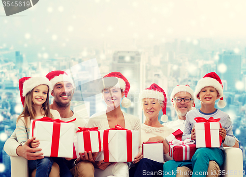 Image of happy family in santa helper hats with gift boxes