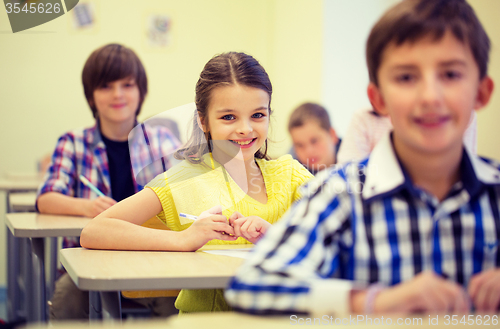 Image of group of school kids with notebooks in classroom