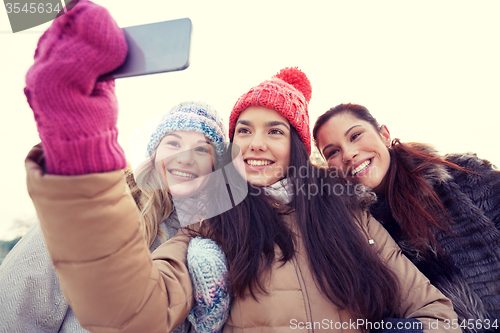 Image of happy teenage girls taking selfie with smartphone