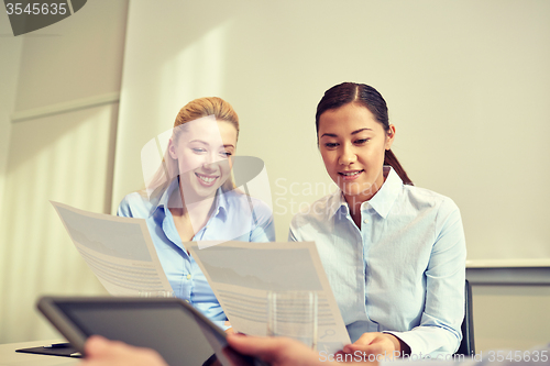 Image of smiling businesswomen meeting in office