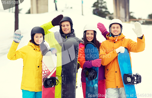 Image of happy friends in helmets with snowboards