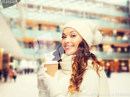 Image of smiling young woman in winter clothes with cup