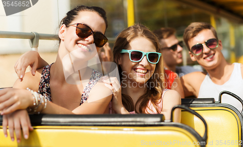 Image of group of smiling friends traveling by tour bus