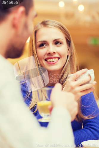 Image of happy couple dating and drinking tea at cafe