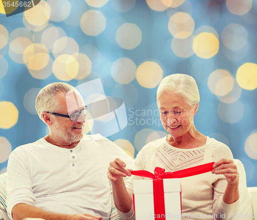 Image of happy senior couple with gift box