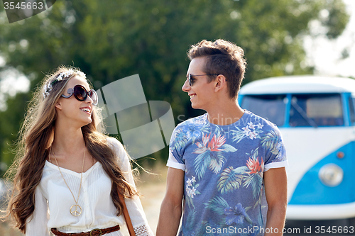 Image of smiling young hippie couple over minivan car