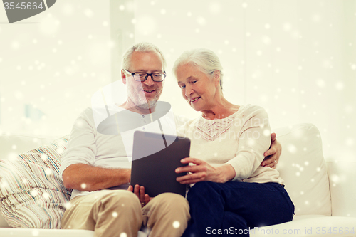 Image of happy senior couple with tablet pc at home