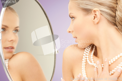Image of beautiful woman with pearl necklace and mirror
