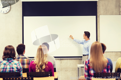 Image of group of students and smiling teacher in classroom