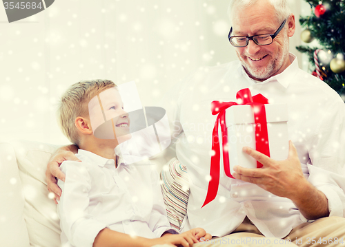 Image of smiling grandfather and grandson at home