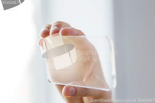 Image of close up of male hand with transparent smartphone