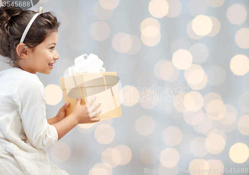 Image of happy little girl with present over lights