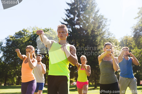 Image of group of friends or sportsmen exercising outdoors