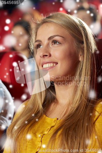 Image of happy young woman watching movie in theater