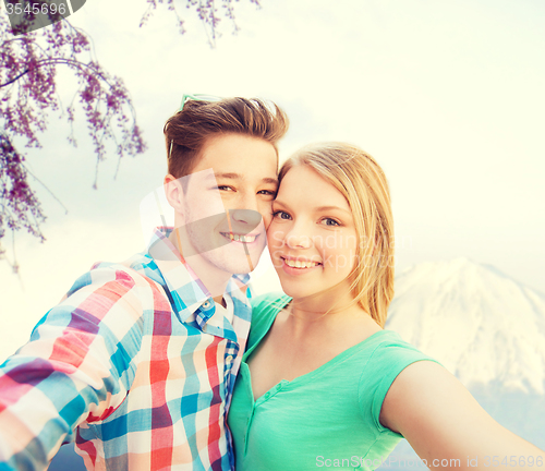 Image of smiling couple with smartphone in city